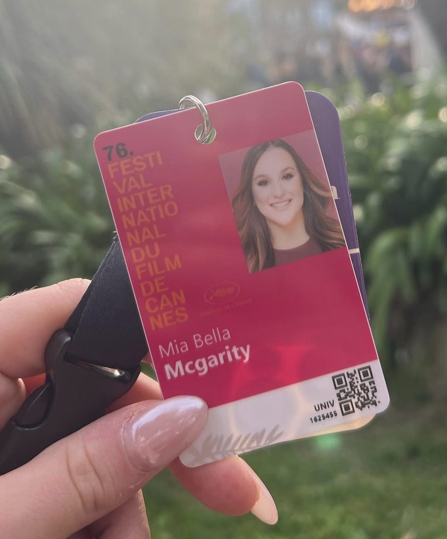 Mia Bella McGarity holding her 76th Festival de Cannes badge